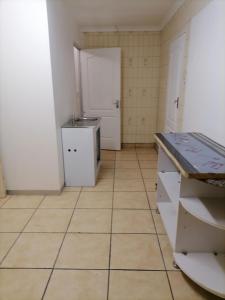 uma cozinha com piso em azulejo e armários brancos em Friends Place em Joanesburgo