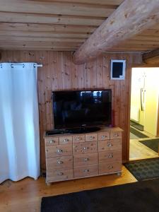 een woonkamer met een televisie op een dressoir bij Det lilla huset in Nora