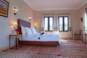 1 dormitorio grande con 1 cama grande y ventanas en Villa Atlas Secret, en Ourika