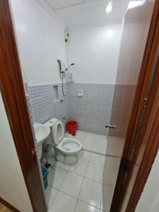 La salle de bains est pourvue de toilettes et d'un lavabo. dans l'établissement Kdc Homes, à Puerto Princesa