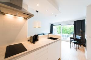 a kitchen with white cabinets and a counter top at Appartement HideAway Nr 96 - Amelander Kaap in Hollum