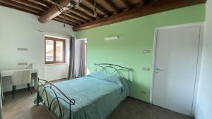 a bedroom with a bed and a desk and a window at Cascina il Germoglio in San Marzano Oliveto