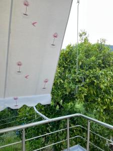 a parasol on a balcony with pink flowers on it at Cheerful 3-Bedroom Private Villa in Borsh! in Borsh
