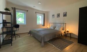 sypialnia z łóżkiem, 2 oknami i dywanem w obiekcie BIKE & FUN Apartments - Balatonakarattya w mieście Balatonakarattya