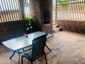 a table and chairs in a patio with a brick oven at Erins Haven - Polokwane in Polokwane