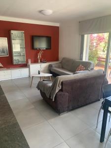 ein Wohnzimmer mit einem Sofa und einem Flachbild-TV in der Unterkunft Casa Roca Maura in L'Estartit