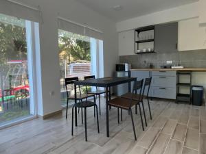 kuchnia ze stołem i krzesłami w pokoju w obiekcie BIKE & FUN Apartments - Balatonakarattya w mieście Balatonakarattya