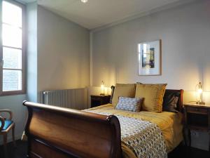 a bedroom with a bed and two tables and two lamps at Planches et Plonk in Belvès