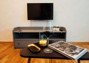 a table with a glass of wine and a magazine at Franz Haus Apartments in Merano