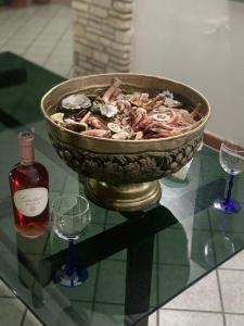 una ciotola di cibo su un tavolo di vetro con una bottiglia di vino di Villa Aristogatti a San Pietro Vernotico
