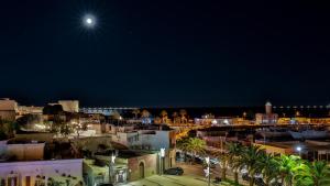 a view of a city at night with the moon at Diomede Rooms - Manfredi Homes&Villas in Manfredonia