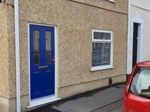 una puerta azul en el lateral de un edificio en Pass the Keys Luxury Bright Spacious Family Home - Near Beaches, en Swansea