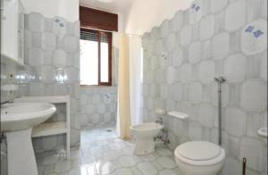 a white bathroom with a toilet and a sink at Gallipoli Mancaversa Futura Vacanza Andrea in Marina di Mancaversa