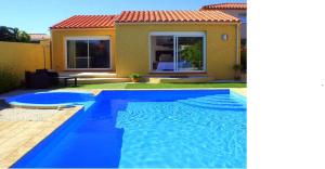 a blue swimming pool in front of a house at SUITE SPA PRIVATIF 66 Nord de Perpignan in Pia