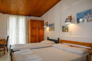 a bedroom with two beds and a window at Hotel Aggeliki in Skopelos Town