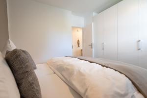 a bedroom with a bed with white cabinets at Käpt'n Gordon, App 2 in Wenningstedt