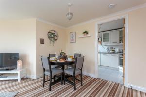 ein Esszimmer mit einem Tisch und Stühlen sowie eine Küche in der Unterkunft Ocean Way Apartment in Leith in Edinburgh