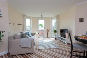 ein Wohnzimmer mit einem Sofa und einem TV in der Unterkunft Ocean Way Apartment in Leith in Edinburgh