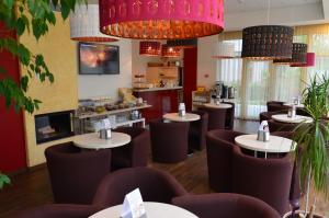 a restaurant with brown chairs and tables and chandeliers at Labas Rytas Vila in Palanga