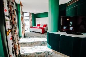 a living room with green walls and a flat screen tv at Ego SPA in Bir&scaron;tonas