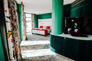 ein Wohnzimmer mit grünen Wänden und einem Flachbild-TV in der Unterkunft Ego SPA in Birštonas