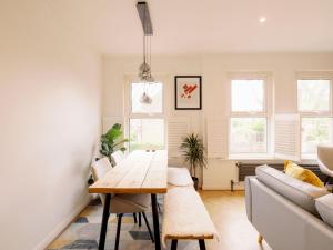 sala de estar con mesa y sofá en Garden Walthamstow Apartment Pass the Keys, en Londres