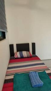 a small bed in a room with a blanket on it at Conezion 3-bedroom condo @ IOI City Mall Putrajaya in Serdang