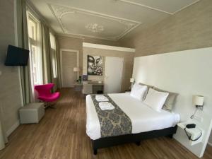 ein Hotelzimmer mit einem Bett und einem roten Stuhl in der Unterkunft Hotel Andante aan Zee in Scheveningen