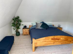 una camera con letto in legno e coperta blu di AMW6a Ferienwohnung Ankerherz a Timmendorfer Strand