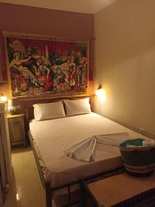 a bedroom with a bed with a painting on the wall at ΠΛΑΤΕΙΑ-PLATIA in Agios Nikolaos