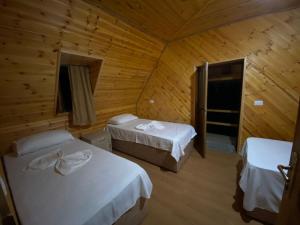 a bedroom with two beds in a wooden cabin at Bujtina Vellezerit Grrela in Theth