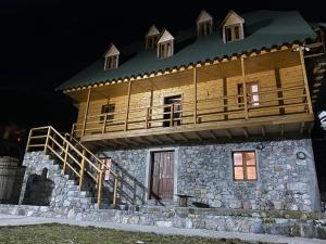 a house with a deck on top of it at Bujtina Vellezerit Grrela in Theth
