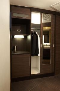 a closet with a glass door and a mirror at Sukhumvit Suites Hotel in Bangkok