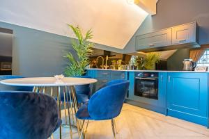 a kitchen with blue cabinets and a table with blue chairs at The Rockefeller Apartments in Bowness-on-Windermere