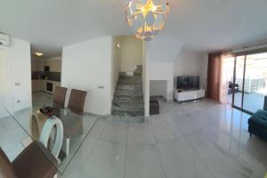 sala de estar con escalera y lámpara de araña en Super cool villa in Los Cristianos, en Los Cristianos