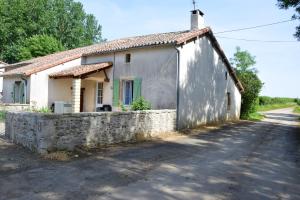 ein kleines Haus mit einer Steinmauer neben einer Straße in der Unterkunft Maison de 3 chambres avec jardin clos a Saint Germier in Saint-Germier