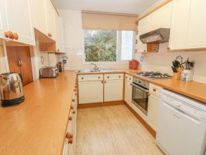 a kitchen with white cabinets and a wooden counter top at Lake House Bowness in Windermere