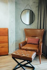 un fauteuil en cuir brun et un miroir dans la chambre dans l'établissement Fairway Hotel & Spa, à Kampala