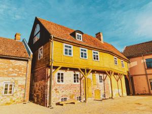 a large yellow building with a brown roof at SĪMANIS Boutique Hotel in Kuldīga