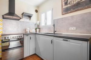 a kitchen with white cabinets and a sink at Casa Sol Cala dor in Cala D'or
