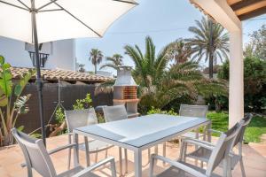 a table and chairs on a patio with an umbrella at Casa Sol Cala dor in Cala D'or
