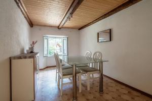 a dining room with a glass table and chairs at Stèla - rustic house in the heart of the Leventina in Lavorgo