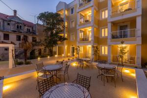 a patio with tables and chairs in front of a building at PORTO SERENO apartments in Šibenik