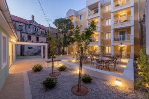 - une cour dans un bâtiment avec une table et des chaises dans l'établissement PORTO SERENO apartments, à Šibenik