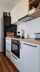 a kitchen with white cabinets and a black oven at Ljubljanotti in Ljubljana