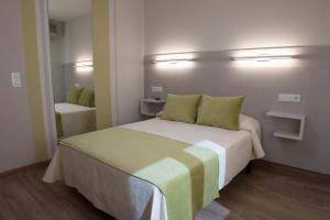 a bedroom with a large bed with green pillows at Hostal Restaurante el Cary in Montemayor