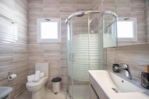 a bathroom with a shower and a toilet and a sink at Tina's Suite by "elite" in Plános +30 photos