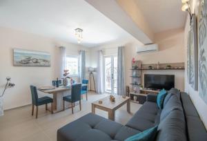 a living room with a blue couch and a table at Tina's Suite by "elite" in Plános