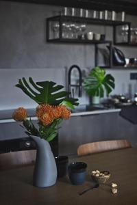 een vaas met bloemen op een tafel in een keuken bij Jaukus butas senamiestyje su vaizdu į Jono kalnelį in Klaipėda