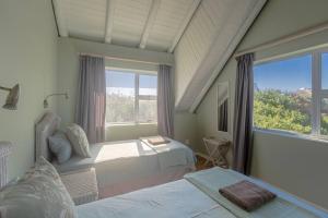 a bedroom with two beds and a large window at Oyster Catcher in Cape St Francis
